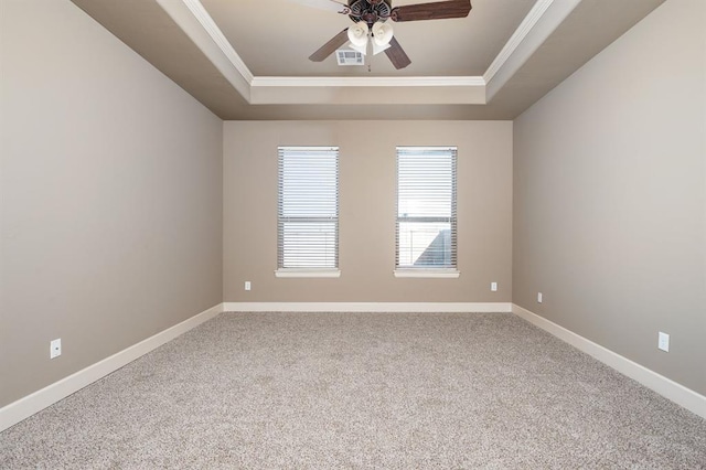 empty room with ceiling fan, ornamental molding, a raised ceiling, and carpet floors