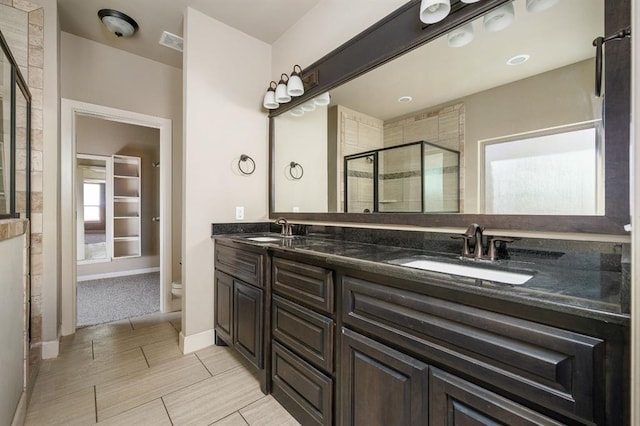 bathroom with vanity, a shower with shower door, and toilet