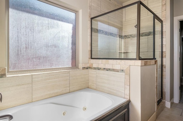 bathroom featuring a healthy amount of sunlight and shower with separate bathtub