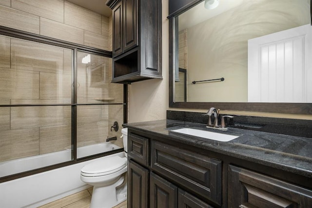 full bathroom featuring vanity, toilet, and combined bath / shower with glass door