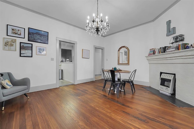 dining room with a chandelier, hardwood / wood-style floors, and heating unit