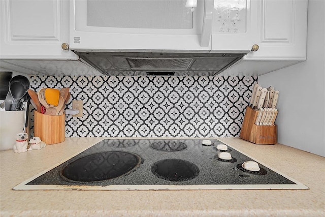 kitchen featuring black electric stovetop and white cabinets