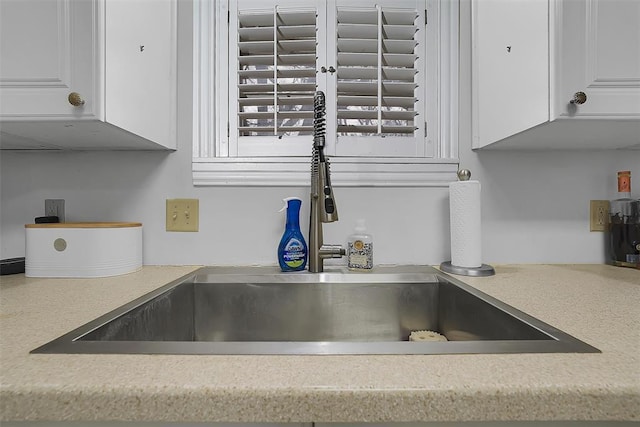 interior details featuring sink and white cabinets