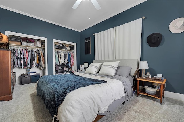 bedroom featuring multiple closets, ornamental molding, carpet, and ceiling fan