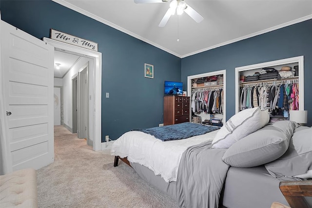 bedroom with multiple closets, ceiling fan, crown molding, and light carpet