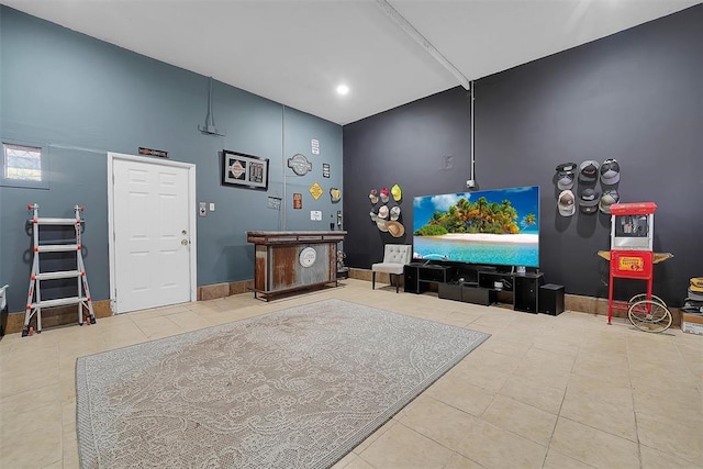 recreation room featuring a towering ceiling and tile patterned floors