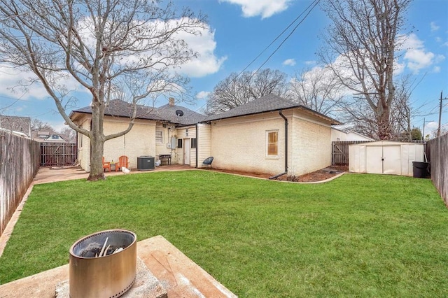 rear view of house with a lawn, cooling unit, and a shed