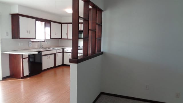 kitchen featuring black dishwasher, sink, backsplash, white cabinets, and light hardwood / wood-style floors