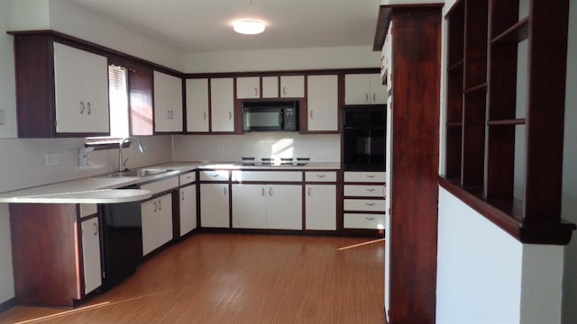 kitchen featuring sink, white cabinetry, backsplash, black appliances, and light wood-type flooring