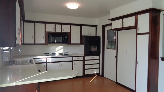 kitchen featuring sink, white cabinets, dark hardwood / wood-style floors, and black appliances