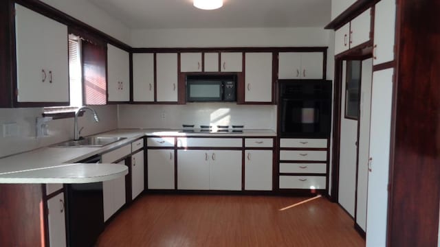 kitchen with white cabinetry, dark hardwood / wood-style flooring, sink, and black appliances