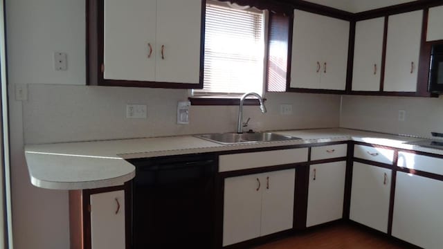 kitchen with dishwasher, sink, white cabinets, and decorative backsplash