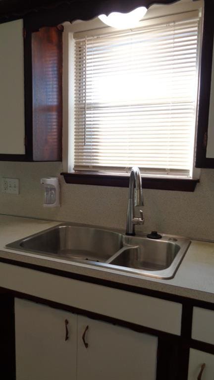 kitchen with white cabinetry and sink