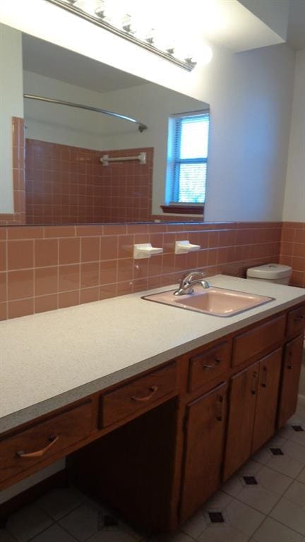 bathroom with tile walls, vanity, tile patterned floors, and toilet