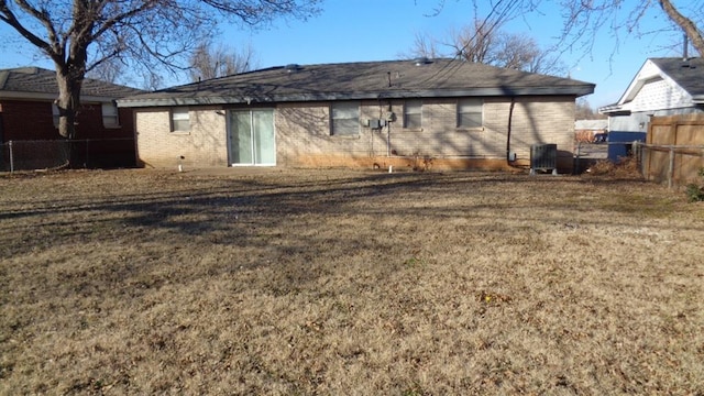 back of house with a yard and central AC unit