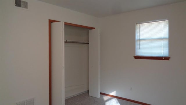 unfurnished bedroom featuring carpet flooring and a closet