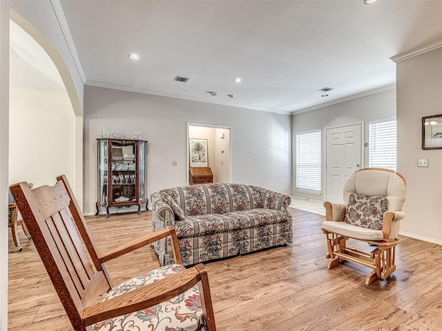 living room featuring crown molding and light hardwood / wood-style floors