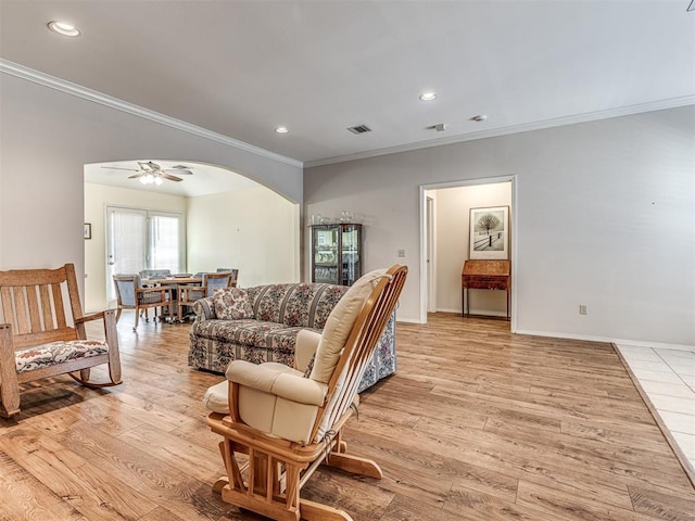 living room with ornamental molding, ceiling fan, and light hardwood / wood-style floors