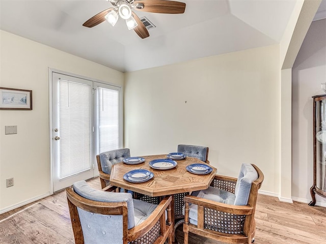 dining room featuring ceiling fan, light hardwood / wood-style floors, and a tray ceiling