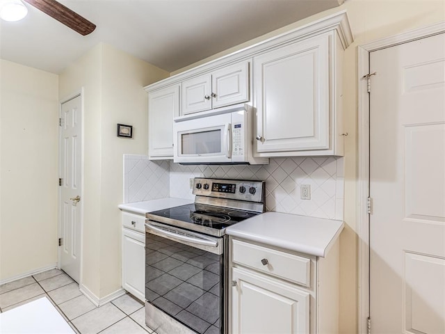 kitchen with light tile patterned flooring, ceiling fan, stainless steel range with electric cooktop, and white cabinets