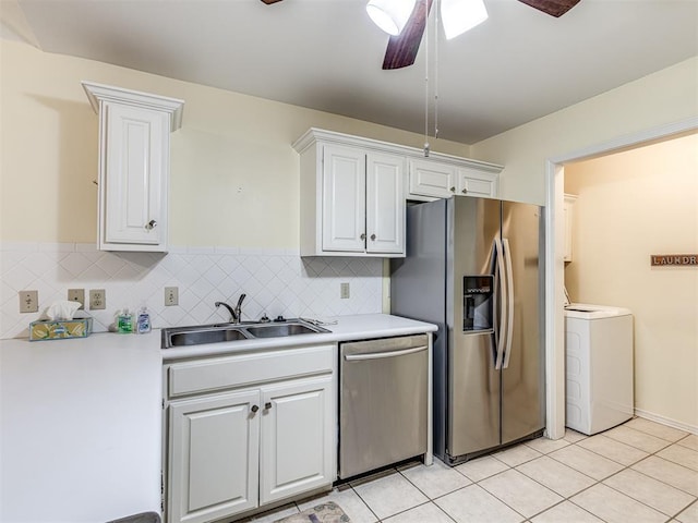 kitchen featuring white cabinetry, stainless steel appliances, washer / clothes dryer, and sink