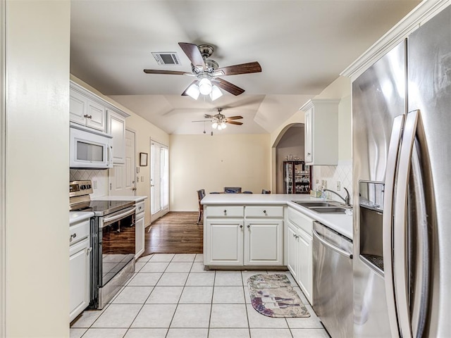 kitchen featuring appliances with stainless steel finishes, tasteful backsplash, sink, white cabinets, and kitchen peninsula