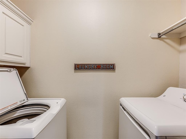 washroom with cabinets and separate washer and dryer