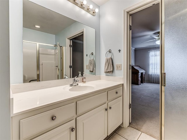 bathroom featuring walk in shower, ceiling fan, vanity, and tile patterned floors