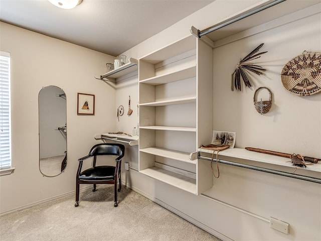 walk in closet featuring light colored carpet