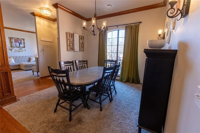 dining space with a notable chandelier, crown molding, and hardwood / wood-style flooring