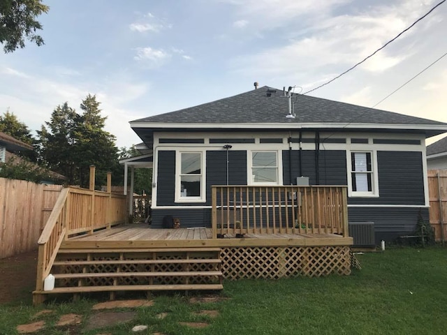 rear view of house featuring central AC unit, a yard, and a deck