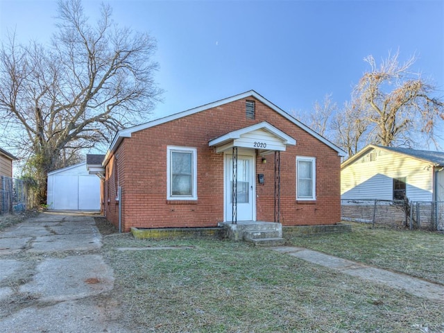 bungalow-style home featuring an outbuilding, a garage, and a front lawn