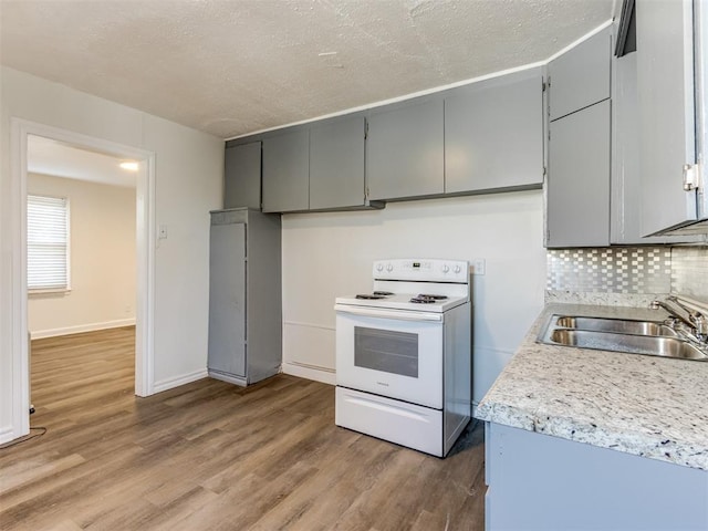 kitchen featuring white electric range, gray cabinets, sink, and hardwood / wood-style floors