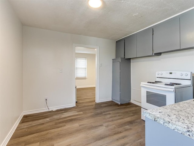 kitchen featuring hardwood / wood-style floors, gray cabinetry, a textured ceiling, and electric stove