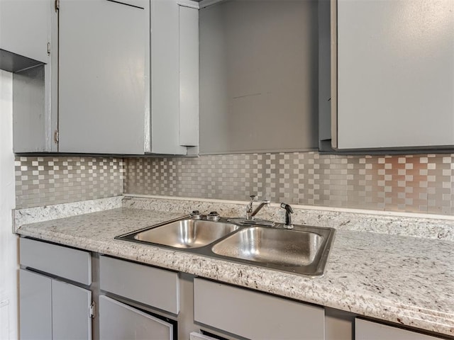 kitchen with gray cabinets, sink, and backsplash