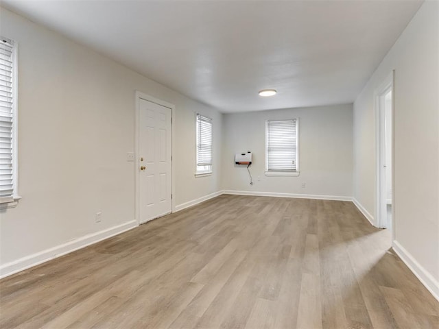 empty room featuring heating unit and light wood-type flooring