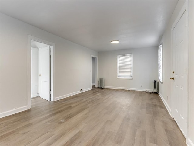 spare room with radiator and light hardwood / wood-style floors