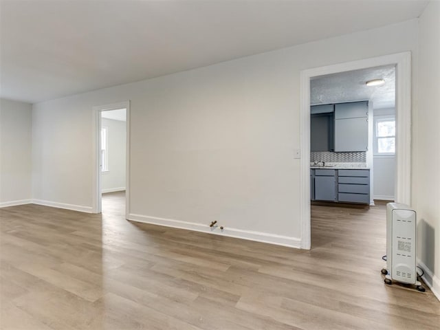 unfurnished room with light hardwood / wood-style flooring and a textured ceiling