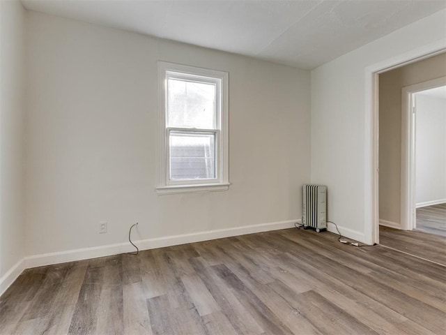 empty room with radiator and light hardwood / wood-style floors