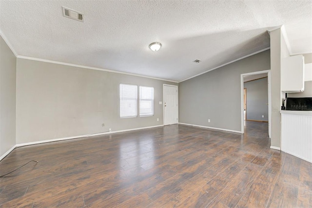 empty room featuring vaulted ceiling, crown molding, dark hardwood / wood-style flooring, and a textured ceiling