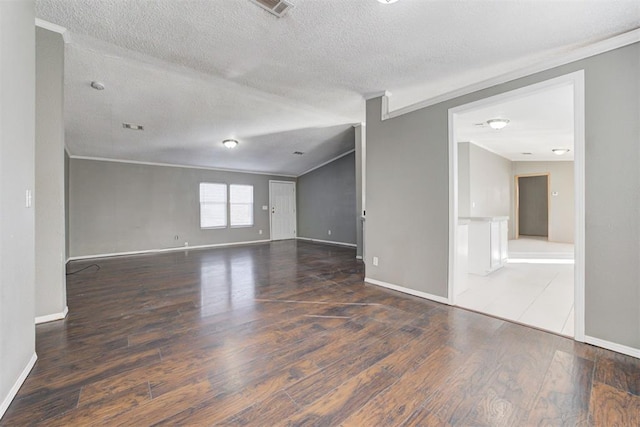 spare room featuring crown molding, a textured ceiling, and dark hardwood / wood-style flooring