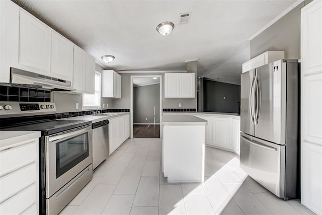 kitchen featuring a center island, white cabinets, sink, stainless steel appliances, and light tile patterned flooring