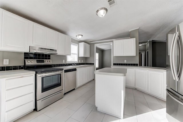 kitchen with white cabinetry, a center island, light tile patterned floors, and appliances with stainless steel finishes