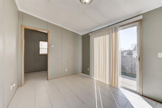 spare room with a textured ceiling, vaulted ceiling, and ornamental molding