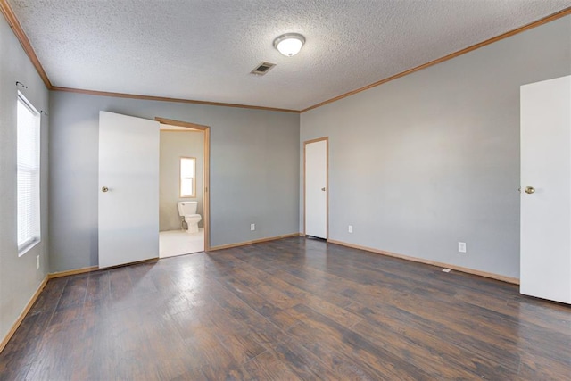 spare room with crown molding, a textured ceiling, dark hardwood / wood-style floors, and vaulted ceiling