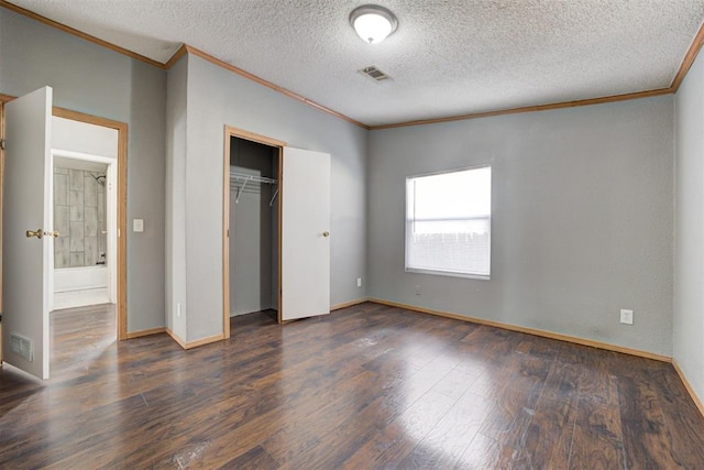 unfurnished bedroom with crown molding, a closet, dark hardwood / wood-style flooring, and a textured ceiling