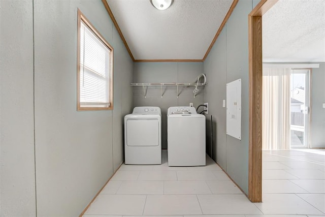 laundry room featuring a healthy amount of sunlight, washing machine and dryer, and ornamental molding