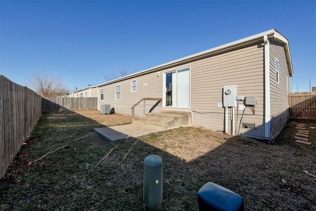 back of property featuring a patio area, central AC unit, and a yard