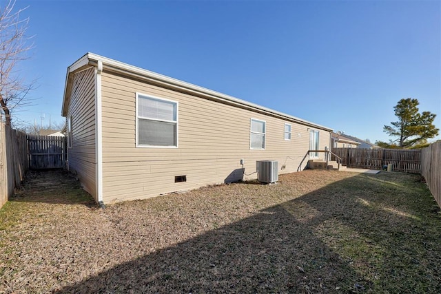 back of house with a lawn and central AC