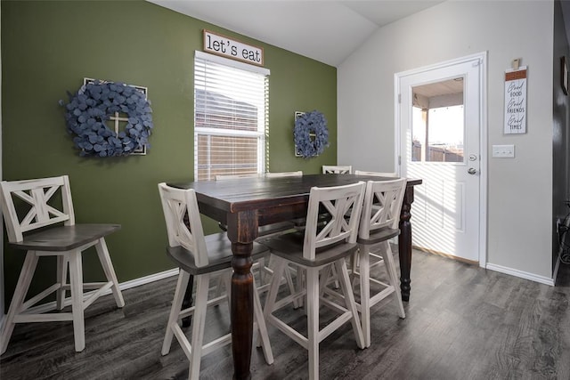 dining space with vaulted ceiling and dark wood-type flooring